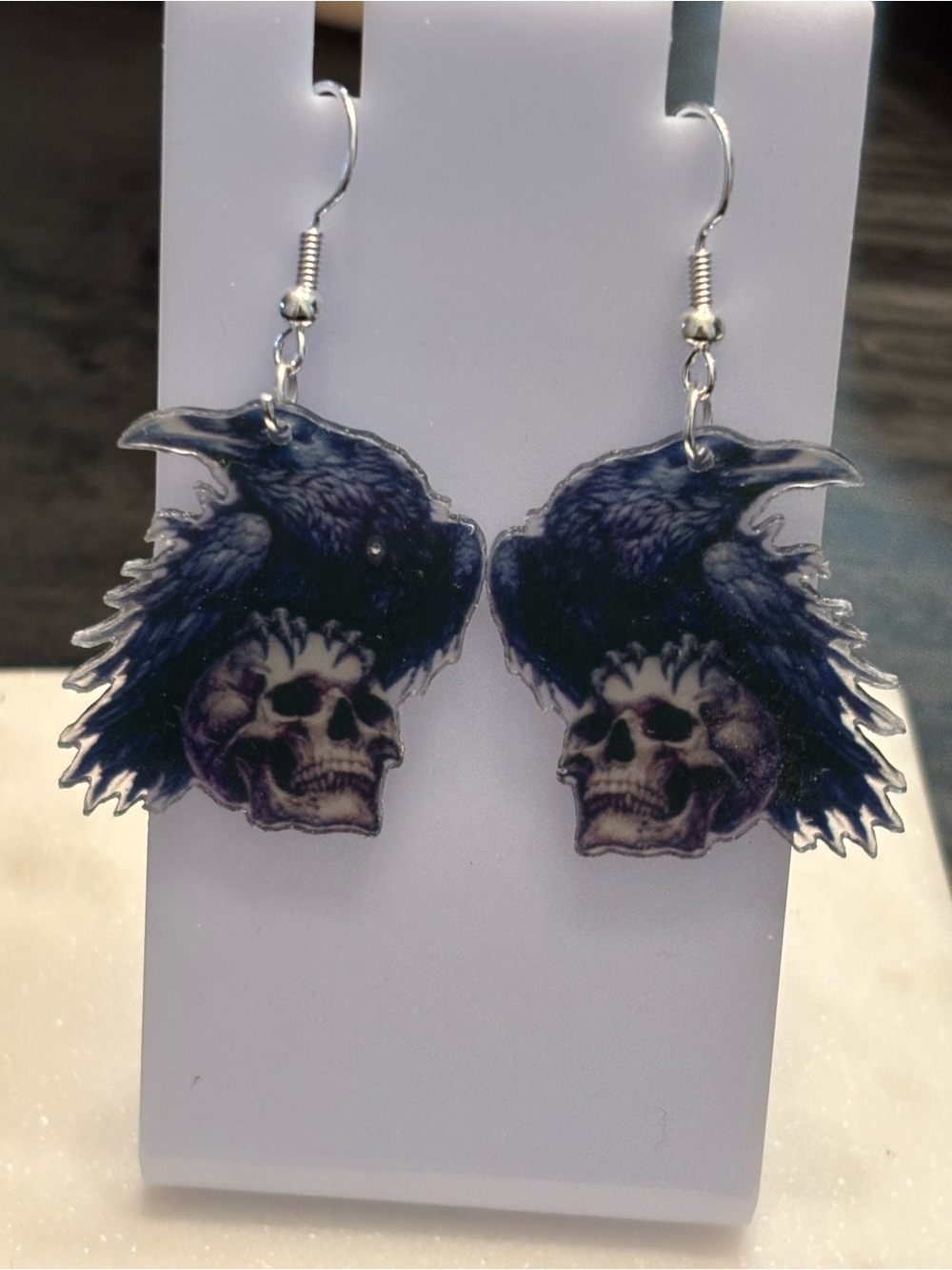 Title: Raven On Skull Acrylic Dangle Earrings | Perched Raven Spread Wings Over